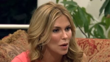 Brandi Glanville sitting on a couch staring off into the distance.