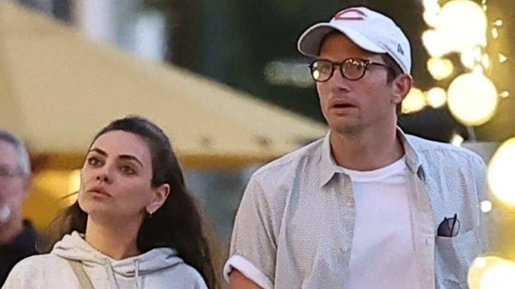 Ashton Kutcher and Mila Kunis hold hands.