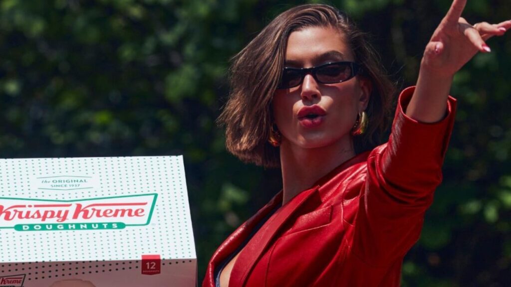 Hailey Bieber holds a pack of Krispy Kreme doughnut