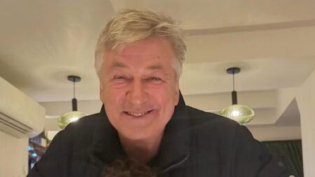 Alec Baldwin poses in black outfiit amid Rust murder trial