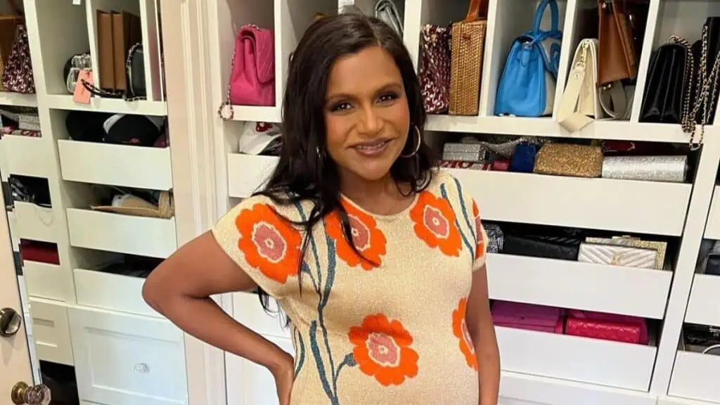 Mindy Kaling in a dress flaunting her baby bump