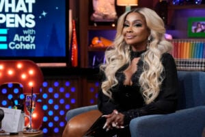 Phaedra Parks sitting in a blue chair in a black dress.