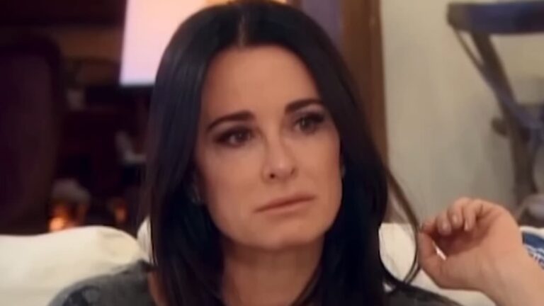 Kim and Kyle Richards No Longer Speaking After Kim Was Placed on Psych Hold Due to Sobriety Concerns Kim Richards sitting on a couch with an upset look on her face.
