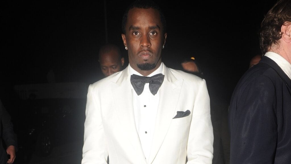 Diddy in a white suit and bow tie.