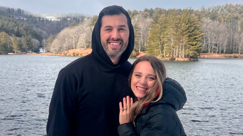 Jinger Duggar Vuolo and her husband Jeremy Vuolo posing on a river bank.