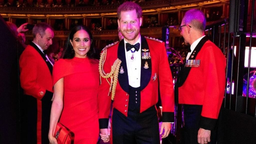 Meghan Markle in a red dress alongside husband Prince Harry.