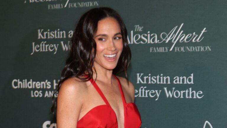 Meghan Markle Acting ‘Single’ As Prince Harry Separation Rumors Heat Up: She Was ‘Touchy-Feely With Everyone’ Meghan Markle smiles in red dress