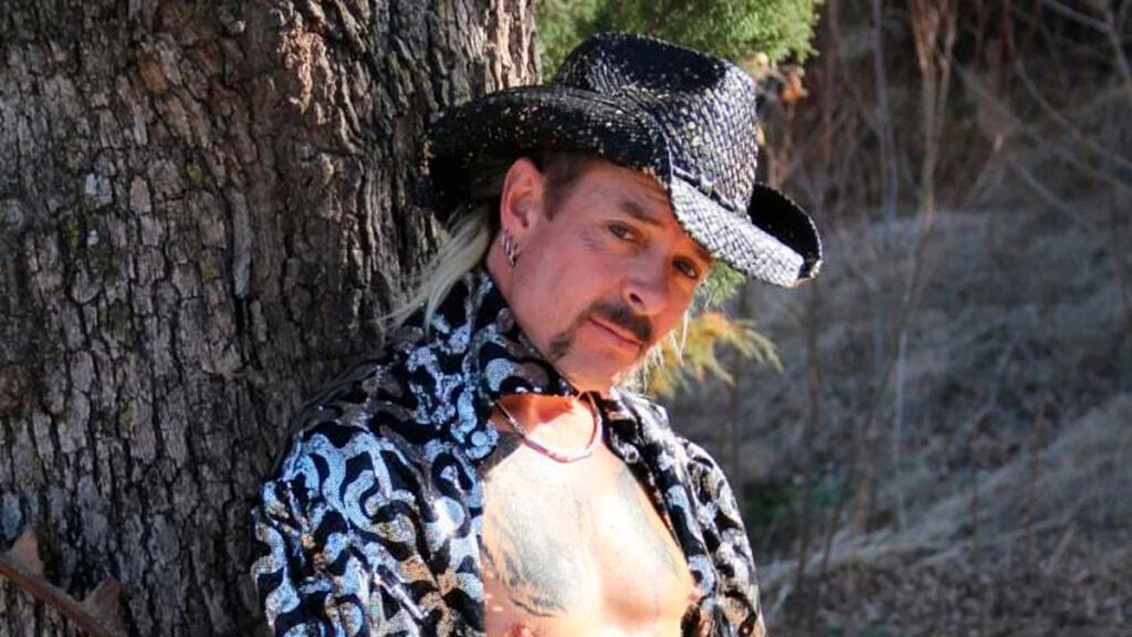 Joe Exotic posing by a tree