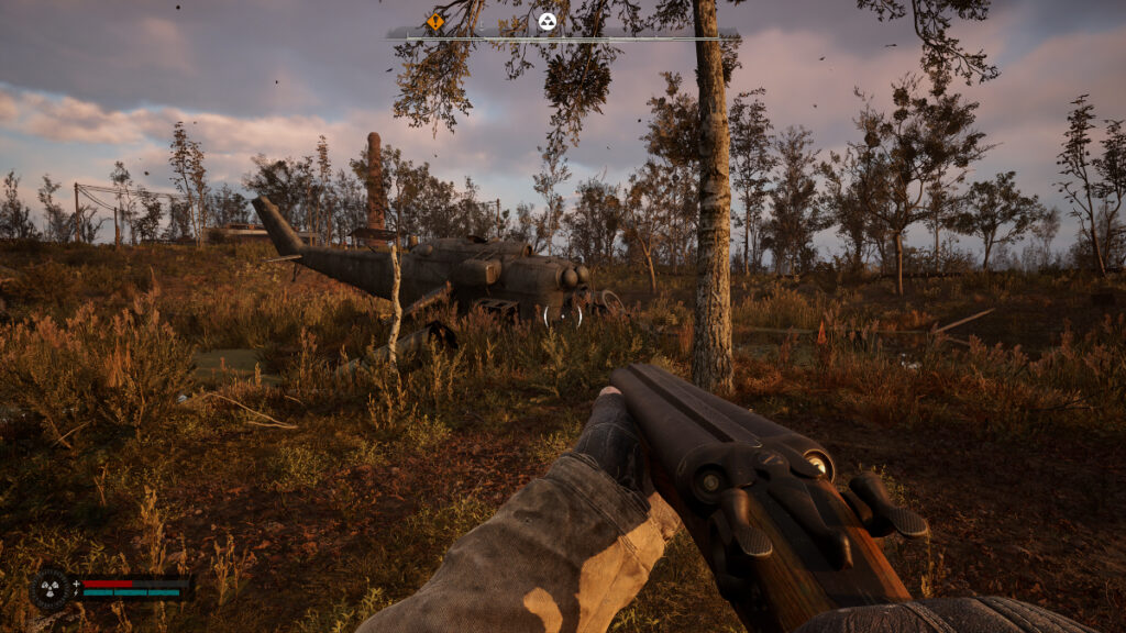 The player approaches a downed helicopter with a shotgun in Stalker 2