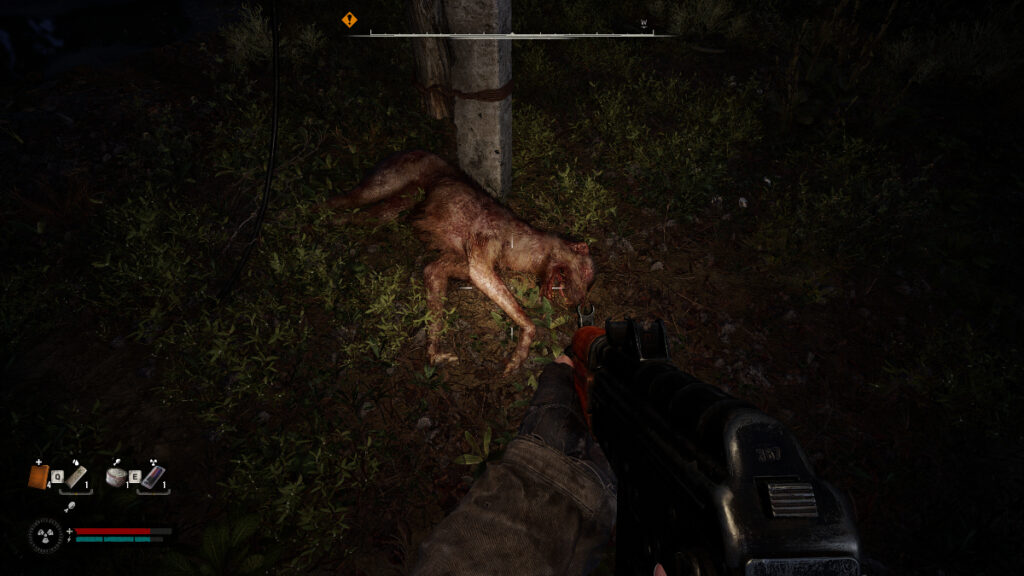 A mutant dog lies dead in the grass at night, illuminated by the player's flashlight