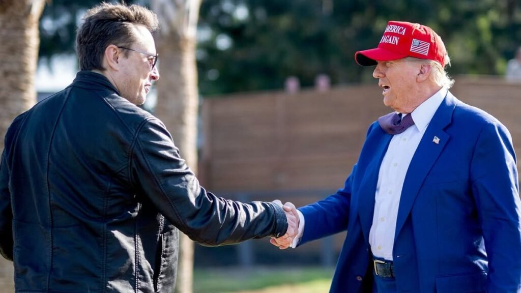 Elon Musk shakes hand with US president Donald Trump.