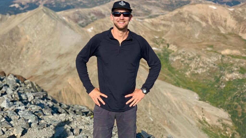 Desert Drifter Andrew Cross posing atop a rocky hill.