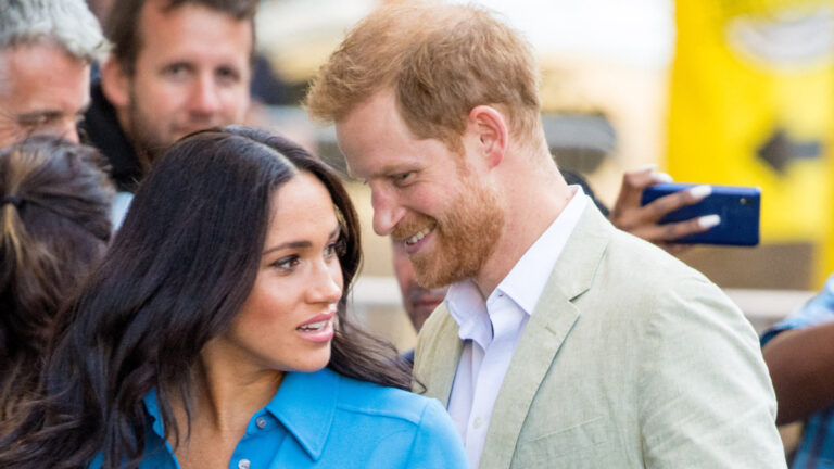 Prince Harry appears to whisper something to his wife, Meghan Markle.