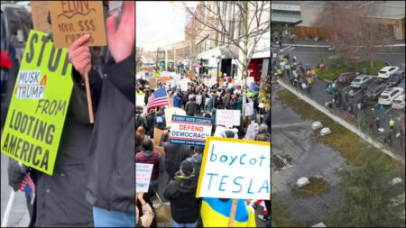 Protestors march with signs as the Tesla protests in Seattle continue to grow