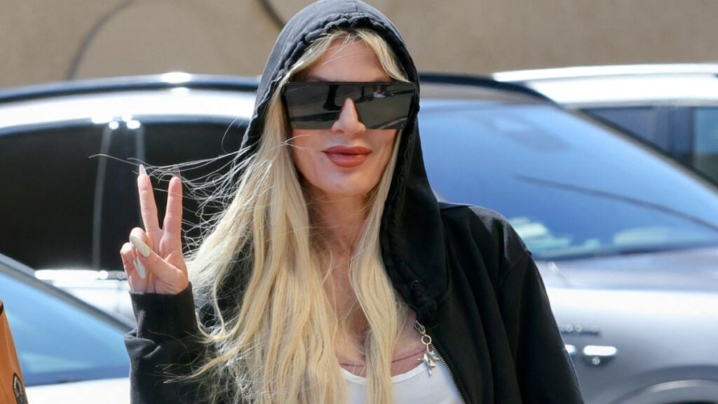 Tori Spelling poses for the cameras with a peace sign outside the DWTS studio.