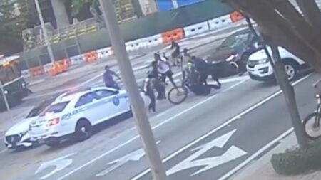 a victim is beaten by cyclists in miami florida, while cop does nothing