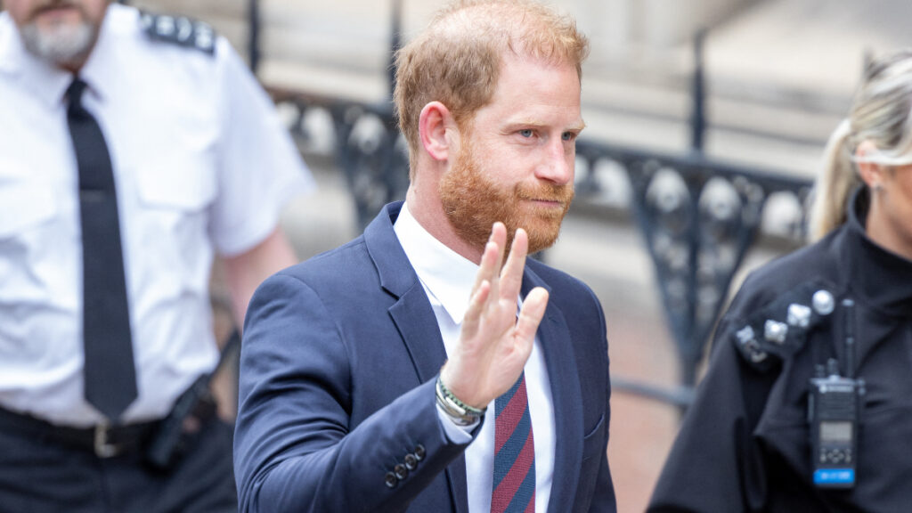 Prince Harry wave at photographers outside the Royals Court of Justice.