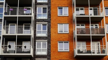 a building with several floors of apartments, painted gray and orange