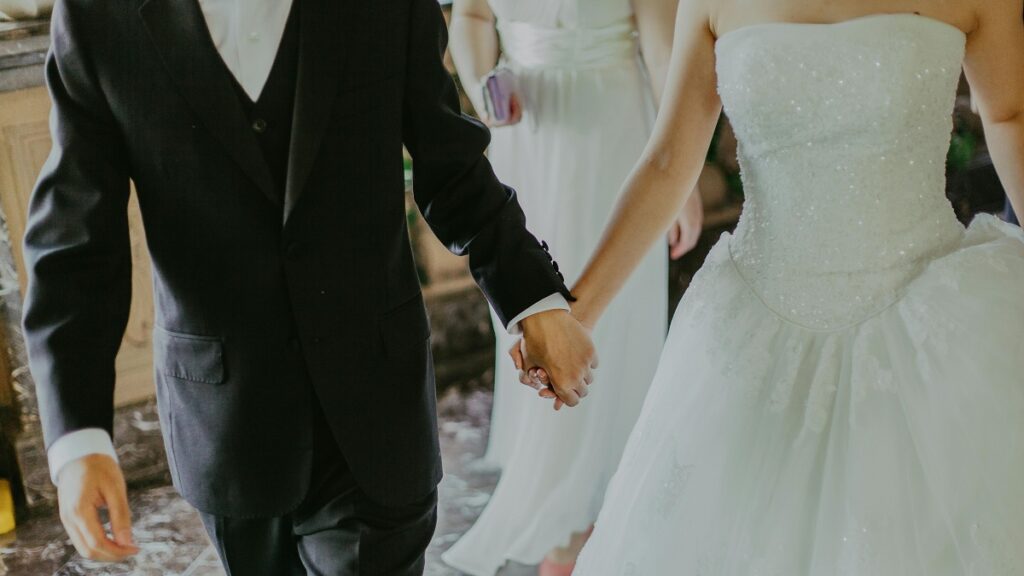 Woman Attends ‘Unorganized Disaster’ Wedding in Washington, ‘Literally Had a Nightmare Similar to This Scenario the Other Night’ a man and woman holding hands, at a wedding