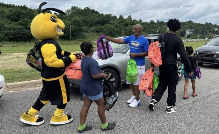 Lane Harper handing out school supplies